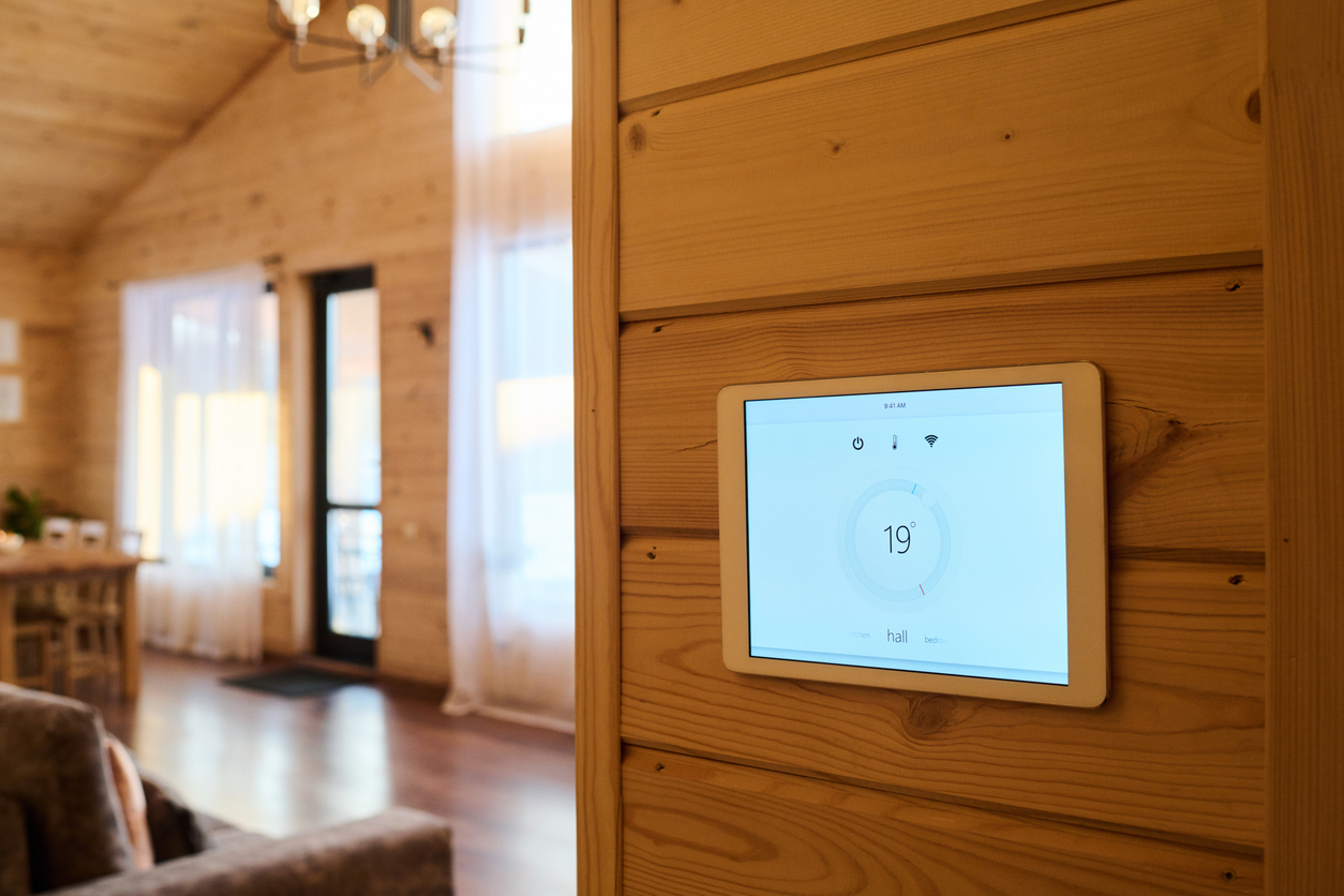Tablet with number nineteen and other signs and symbols on interactive screen hanging on wooden wall against part of living room