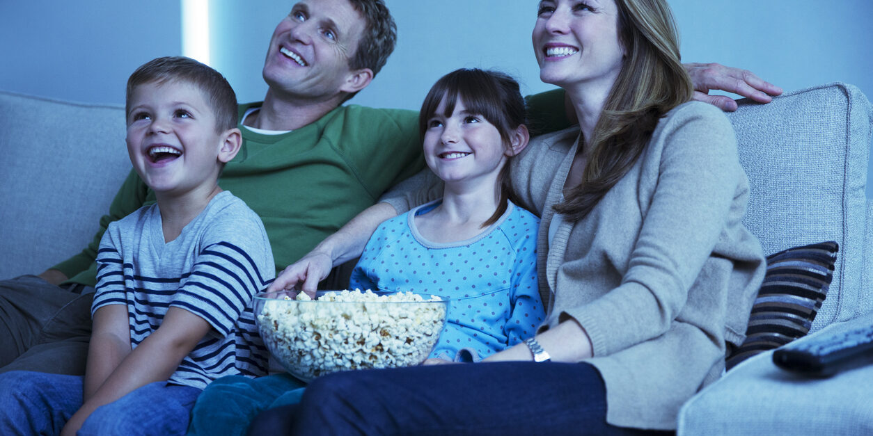 Family watching television in living room